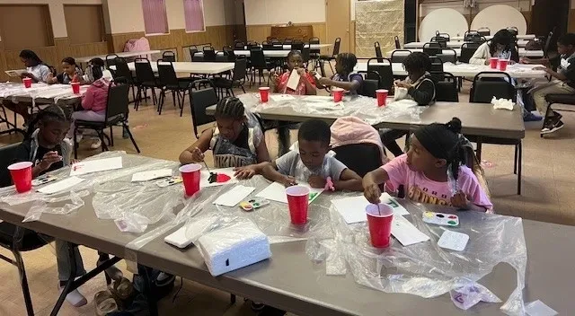 Children painting at a community center event.