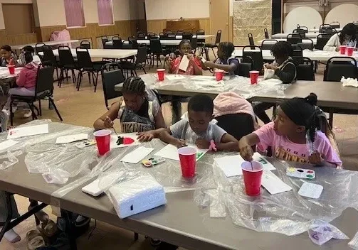Children painting at a community center event.